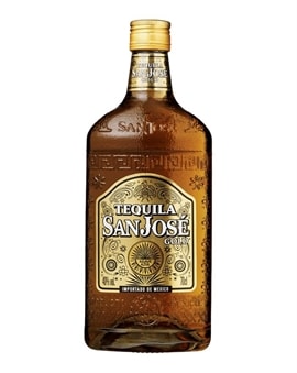 Gylden tequilaflaske foran lys baggrund